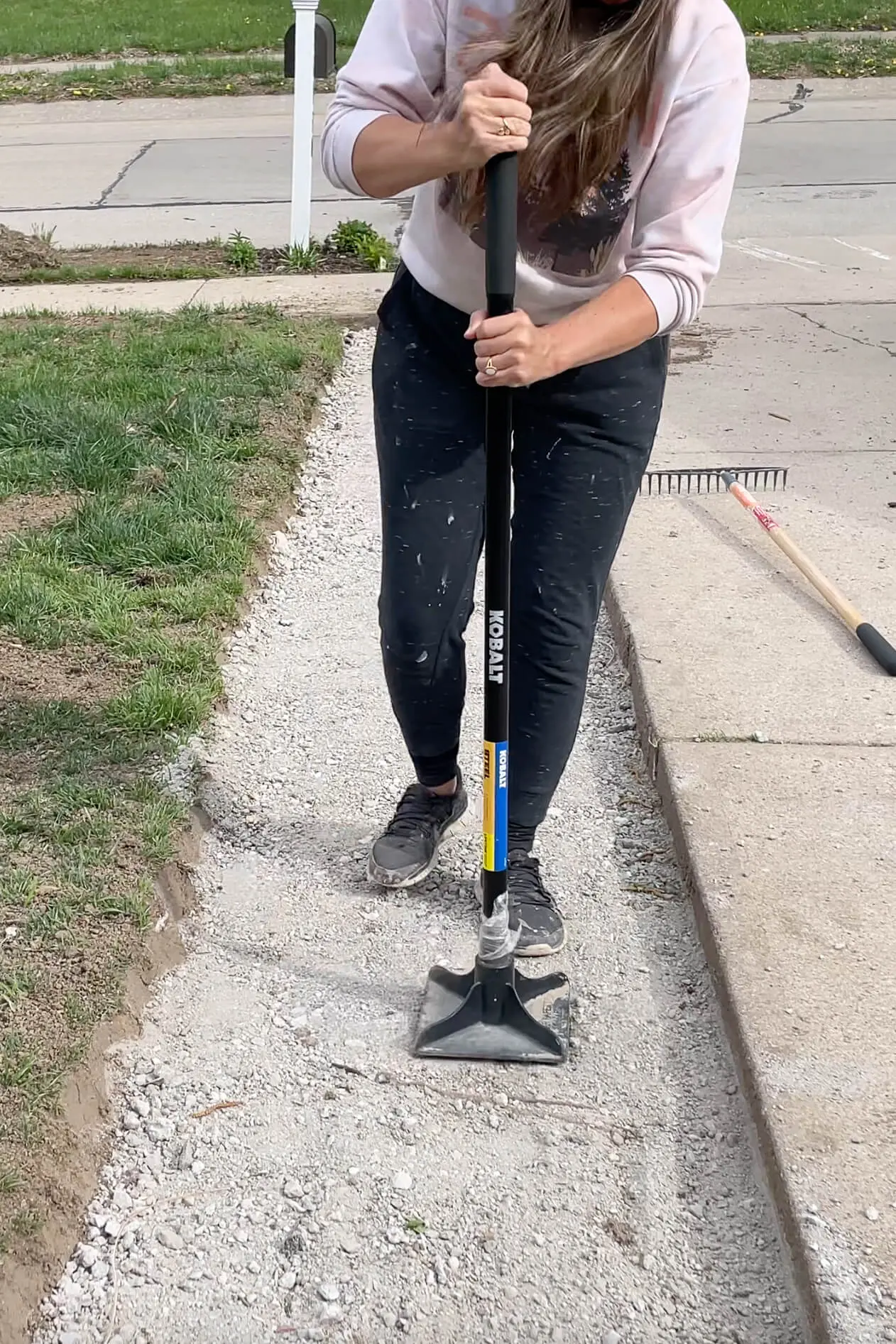 Tamping down road base before laying a paver driveway.